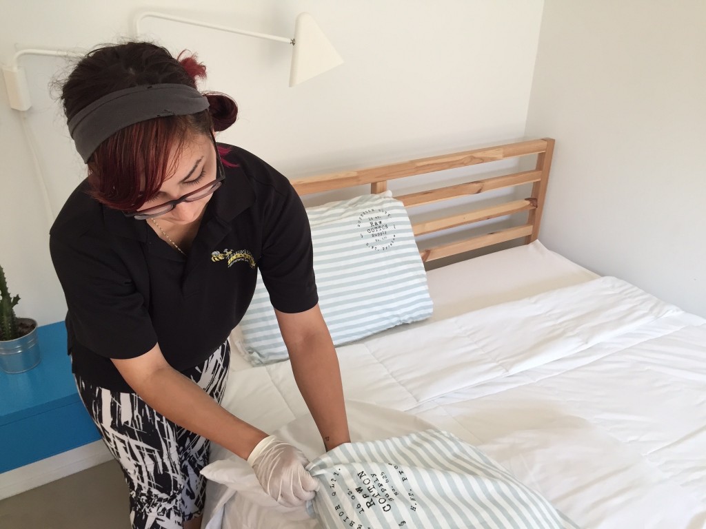 Young attractive lady folding sheets.
